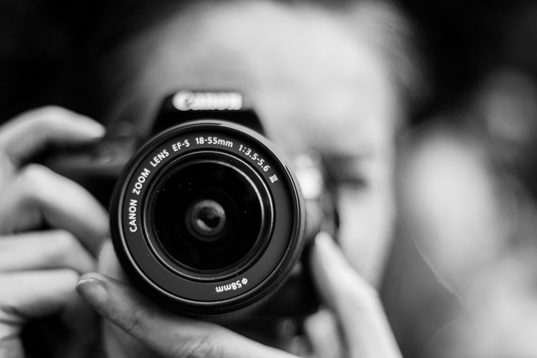 person-taking-photo-using-canon-camera-in-shallow-focus-lens-jkzs3oi9pq0